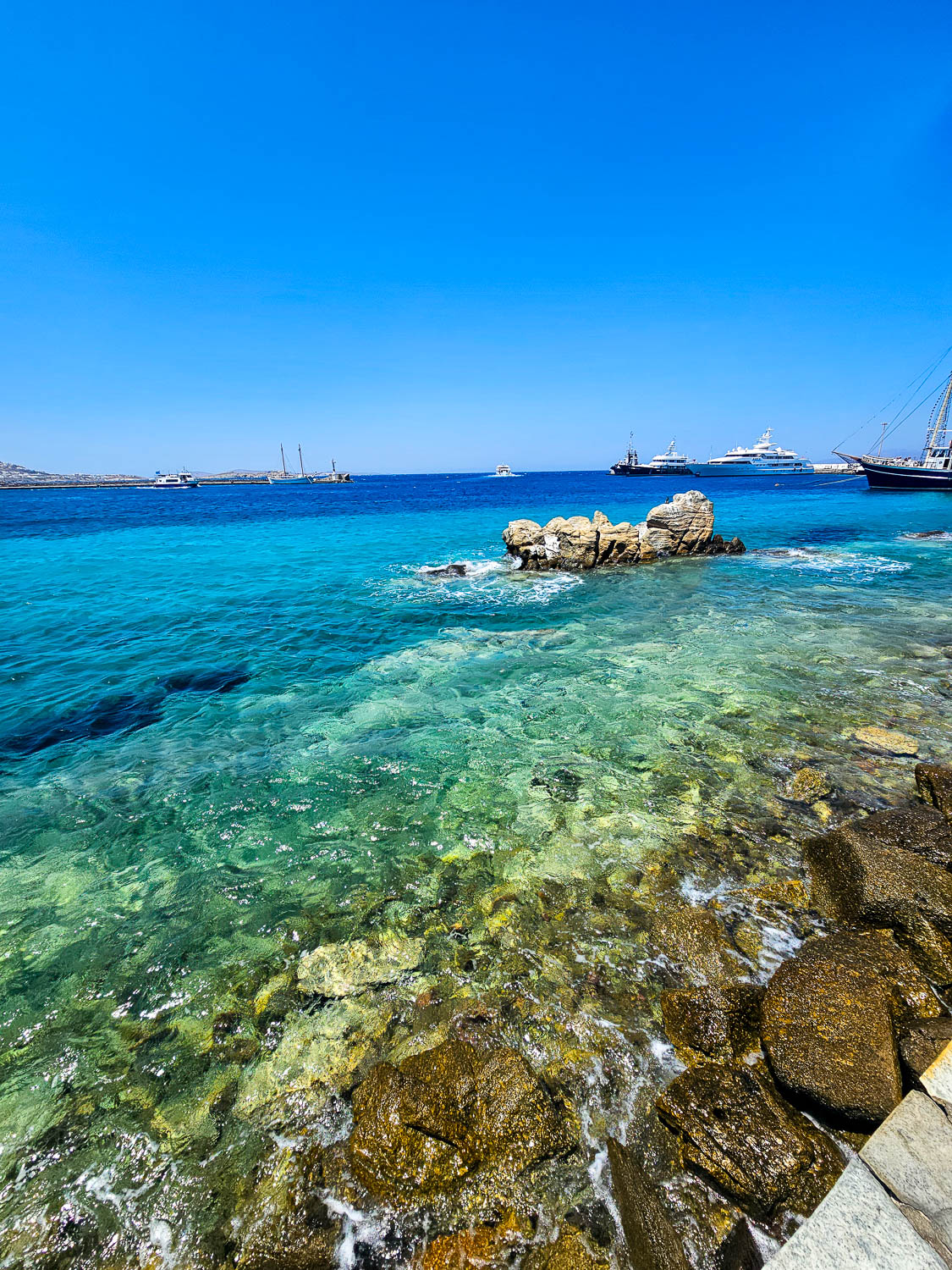 Sailing through crystal-clear waters near Mykonos (Greece)