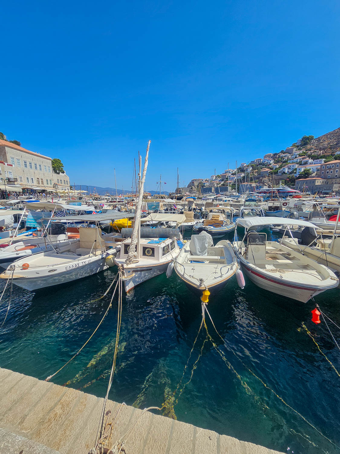Boats in the crystal-clear waters of Hydra harbor