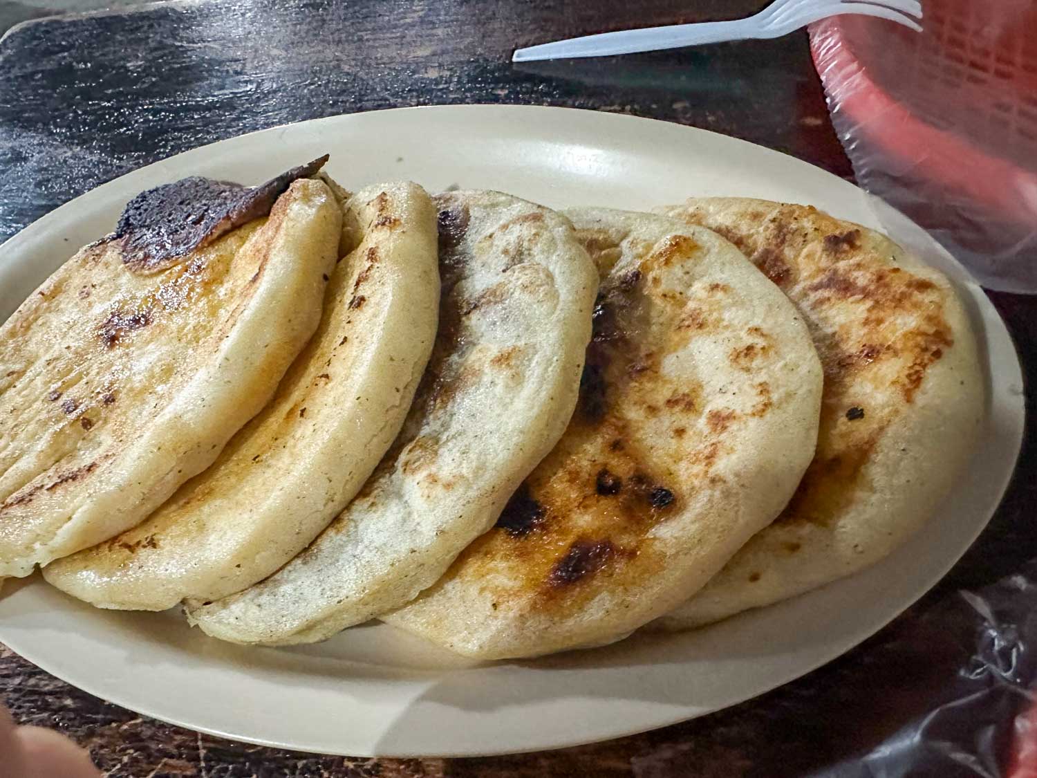 Traditional Salvadoran pupusas served with curtido and salsa
