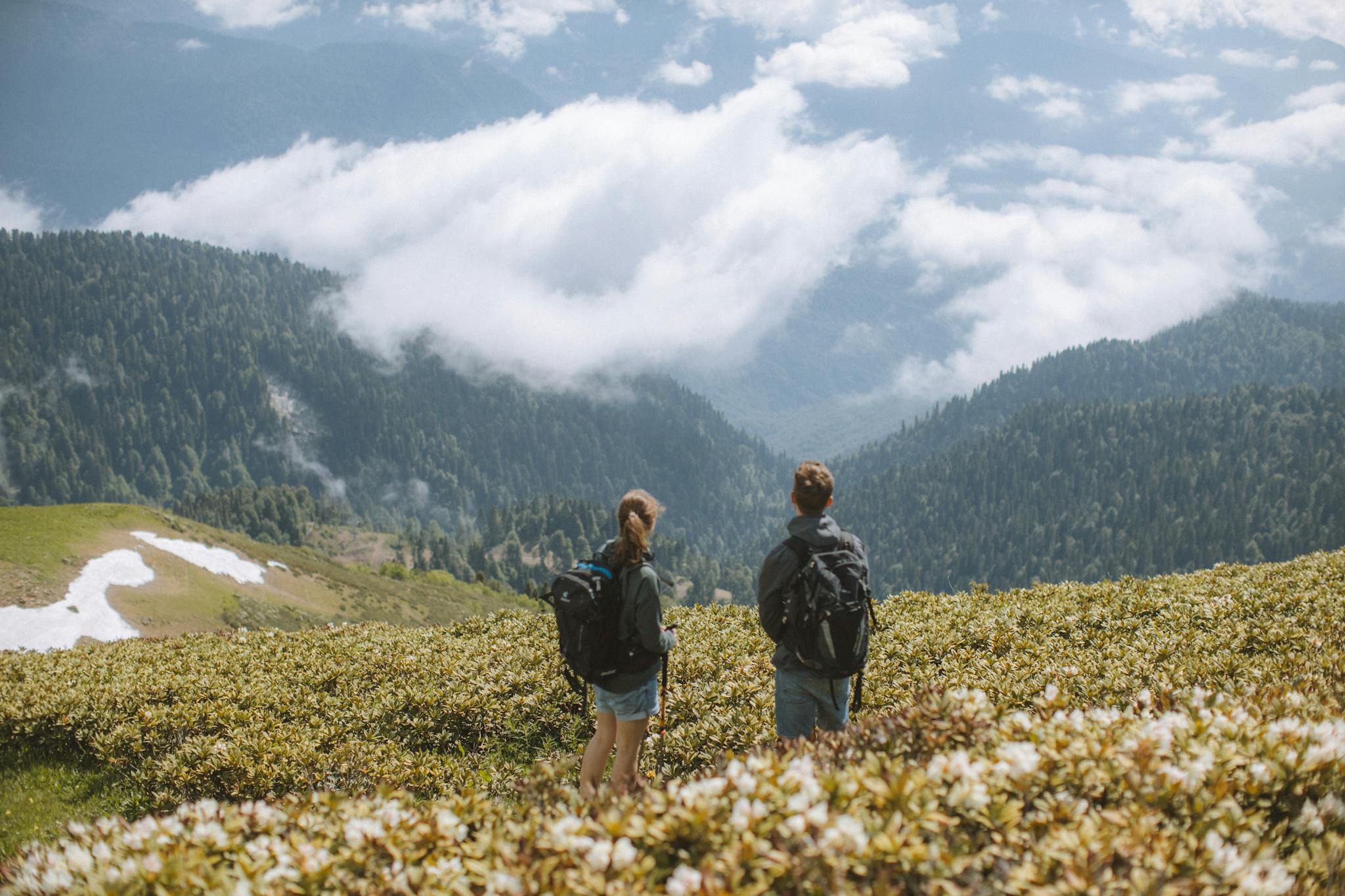 two hikers with backpacks admire a stunning