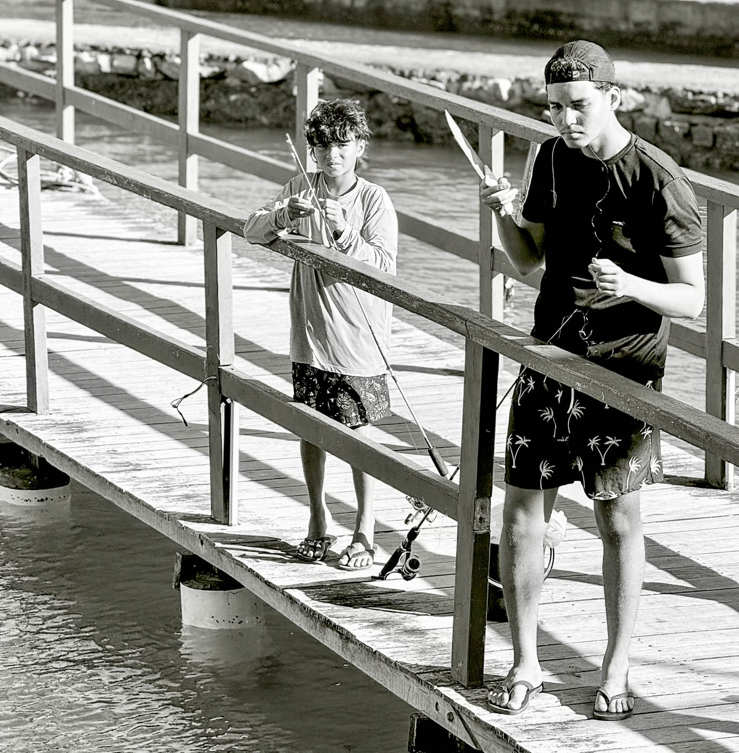 Local fishermen standing on a pier at Barra de Sao Miguel near Maceio Brazil