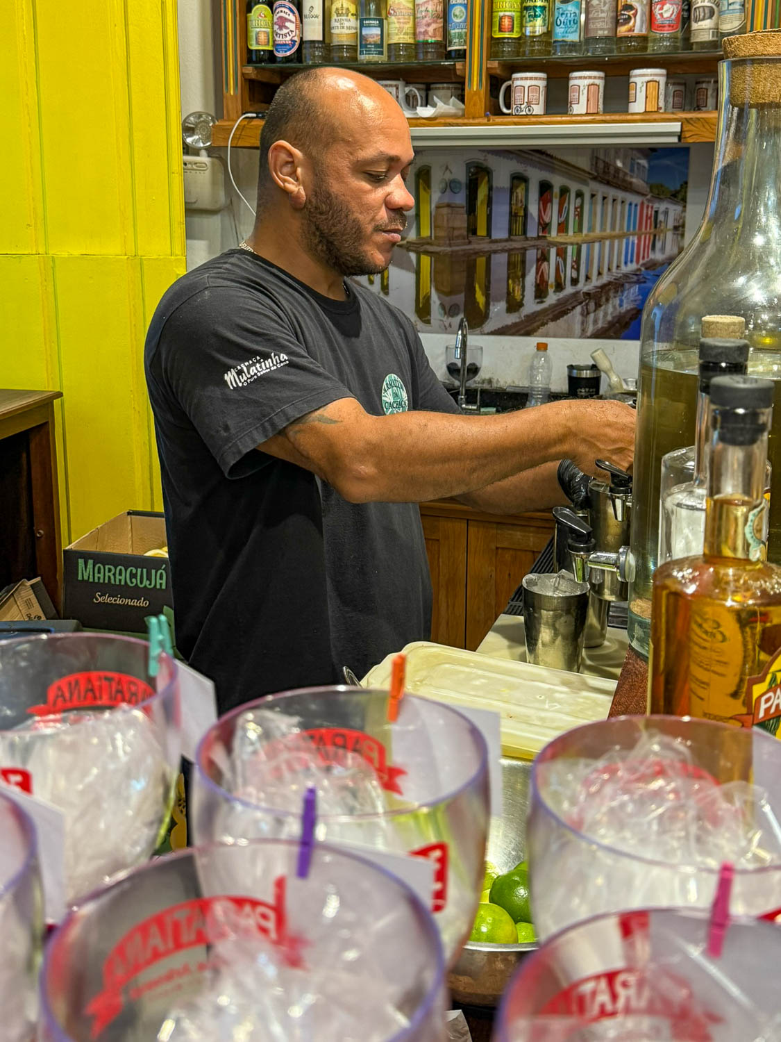 Bartender preparing passionfruit caipirinha cocktail in Paraty Brazil