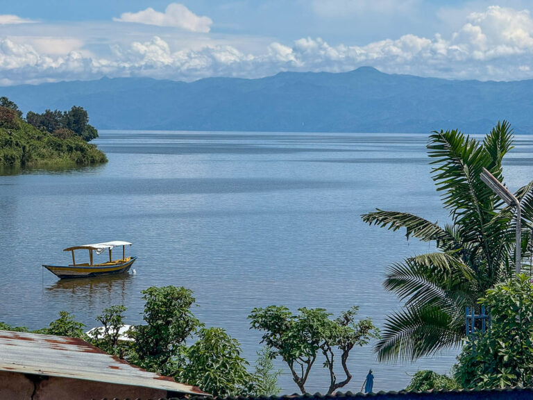 Mirror-like surface of Lake Kivu in Rwanda surrounded by green hills