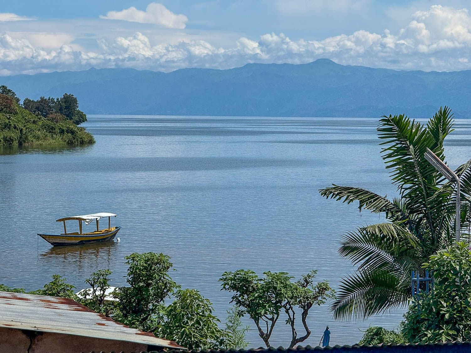 Mirror-like surface of Lake Kivu in Rwanda surrounded by green hills