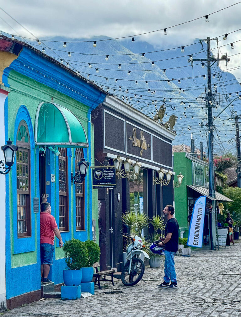 Everyday life along Rua das Flores, a colorful cobblestone street in the historic center of Morretes, Paraná, Brazil.