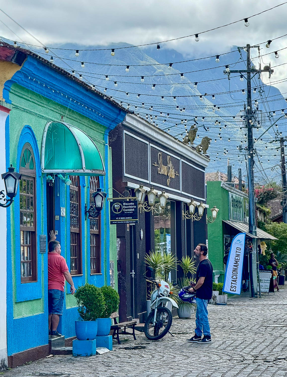 Everyday life along Rua das Flores, a colorful cobblestone street in the historic center of Morretes, Paraná, Brazil.