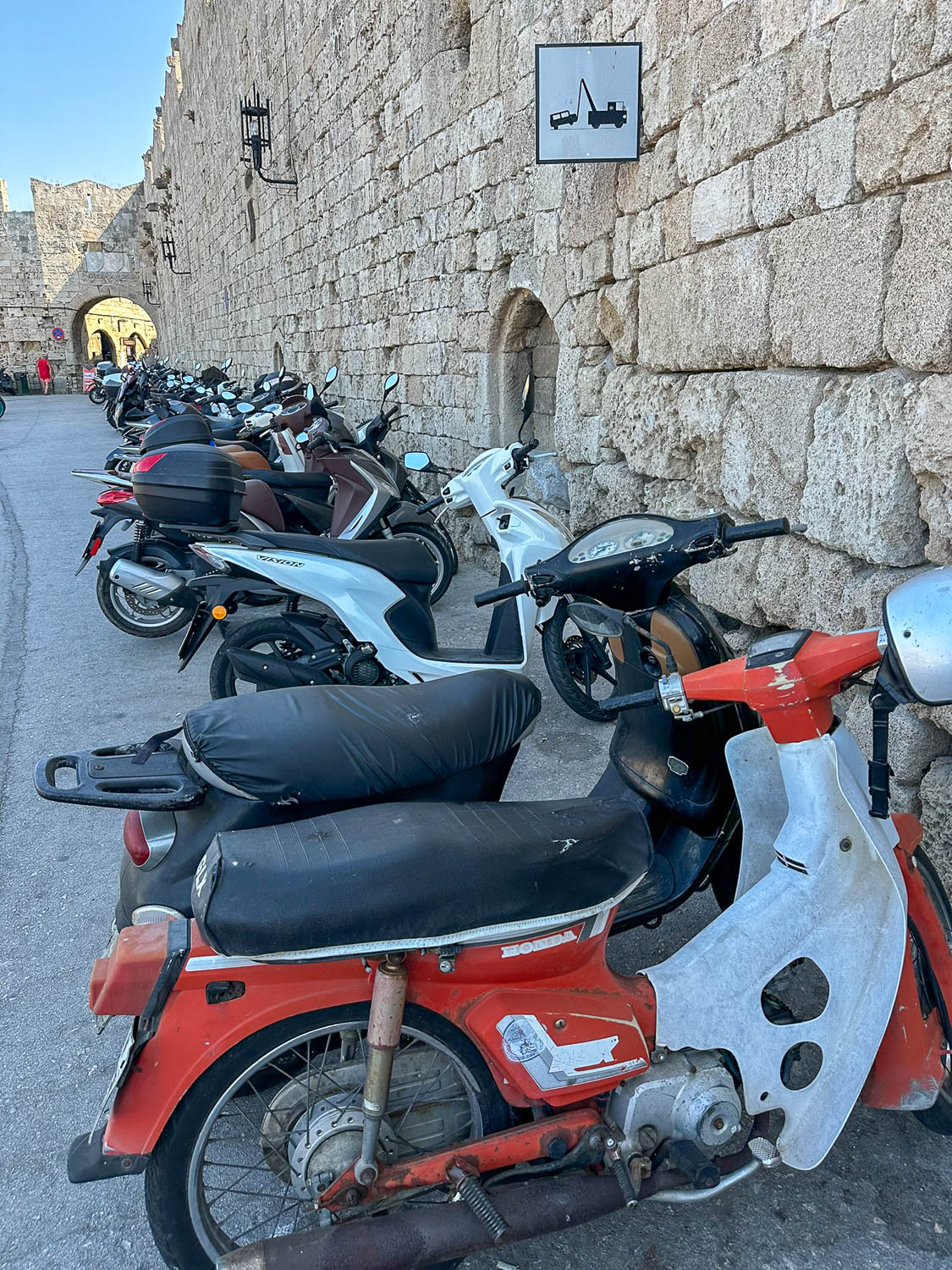 Old Town Rhodes, Greece: The Best Things To Do and See 10 Visitors in Old Town Rhodes Greece with mopeds parked along historic walls