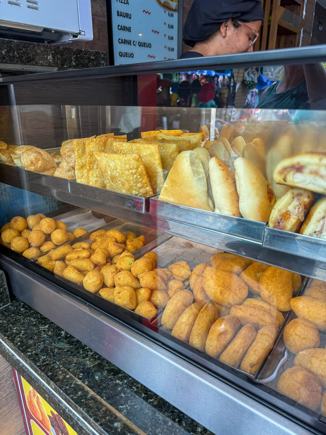 Traditional Brazilian Food: Iconic Dishes, Snacks, and Desserts 22 Brazilian pastéis fried pastries displayed at a snack counter