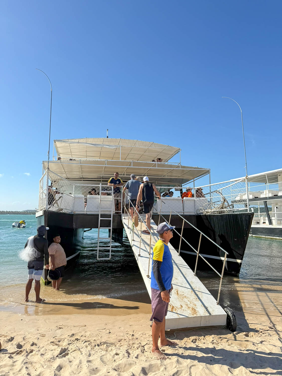 Passengers boarding a schooner boat at Roteiro Lagoon near Gunga Beach in Alagoas Brazil