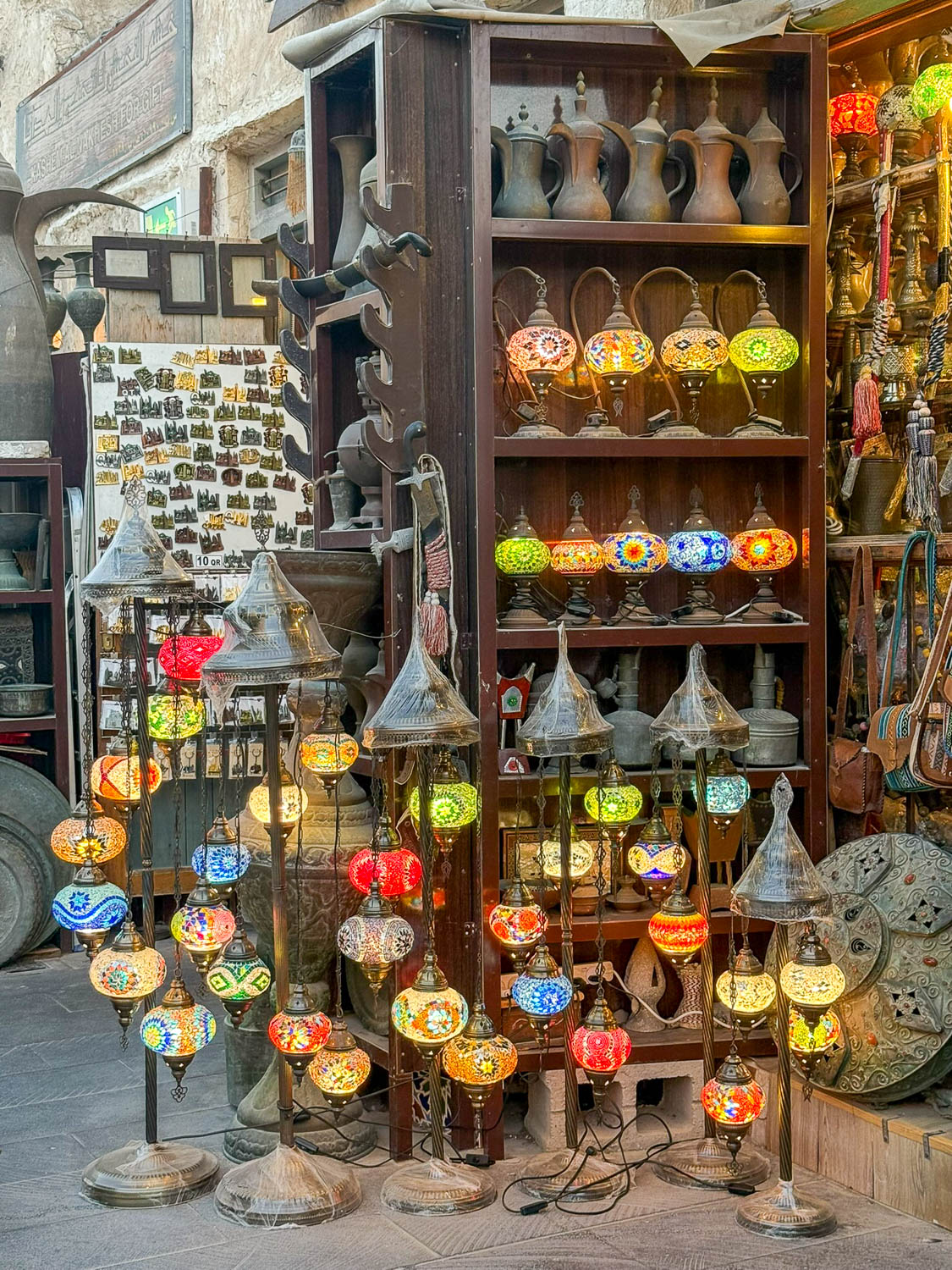 Visitors bargaining with vendors at Souq Waqif in Doha Qatar while shopping for unique souvenirs