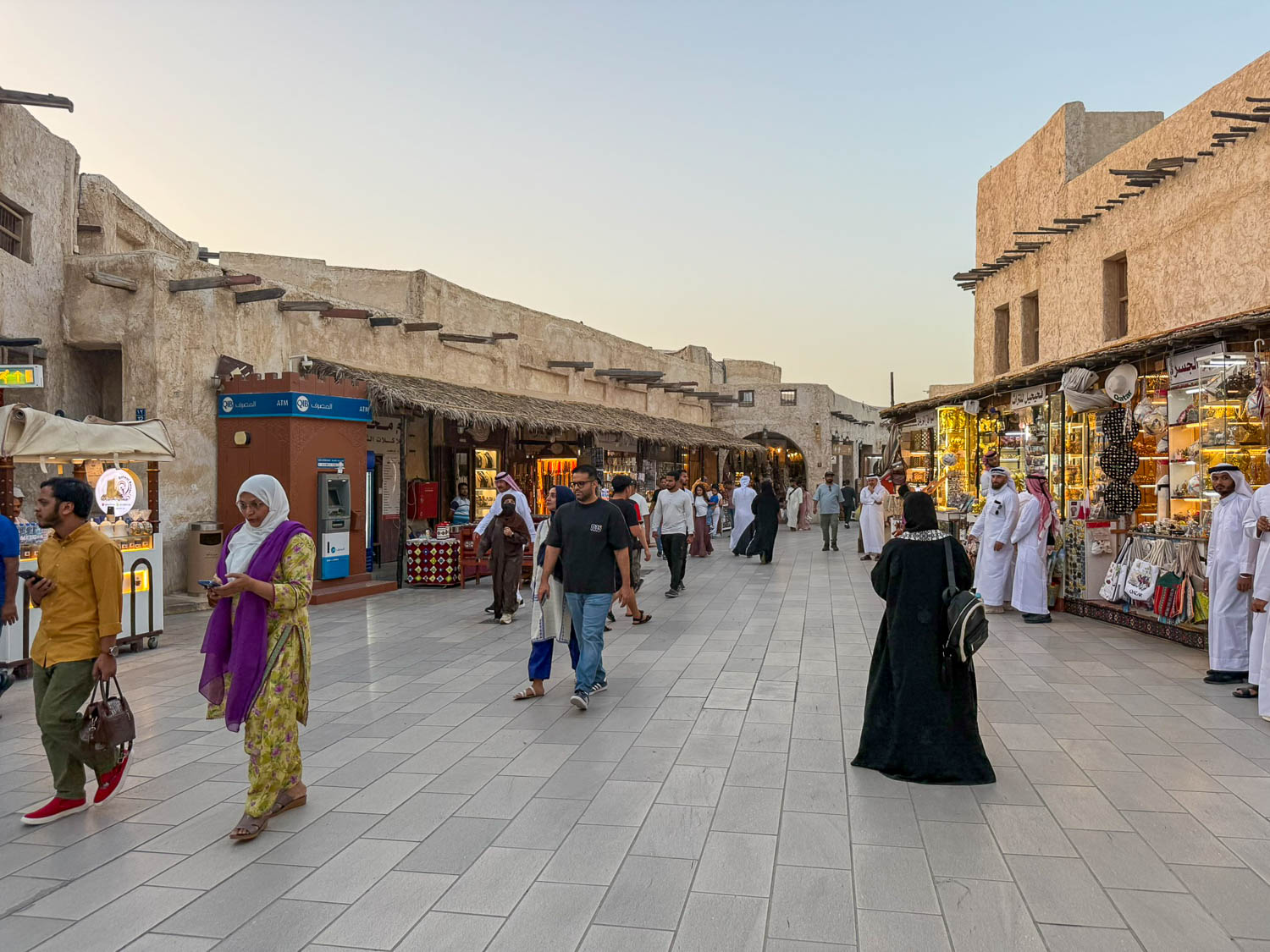 Visitors wearing modest clothing at Souq Waqif in Doha Qatar respecting local cultural dress guidelines