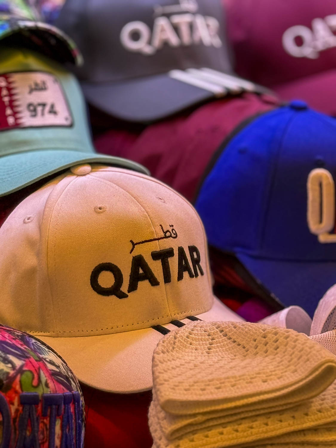 Qatar souvenir caps displayed at Souq Waqif in Doha Qatar featuring local merchandise and traditional marketplace shopping