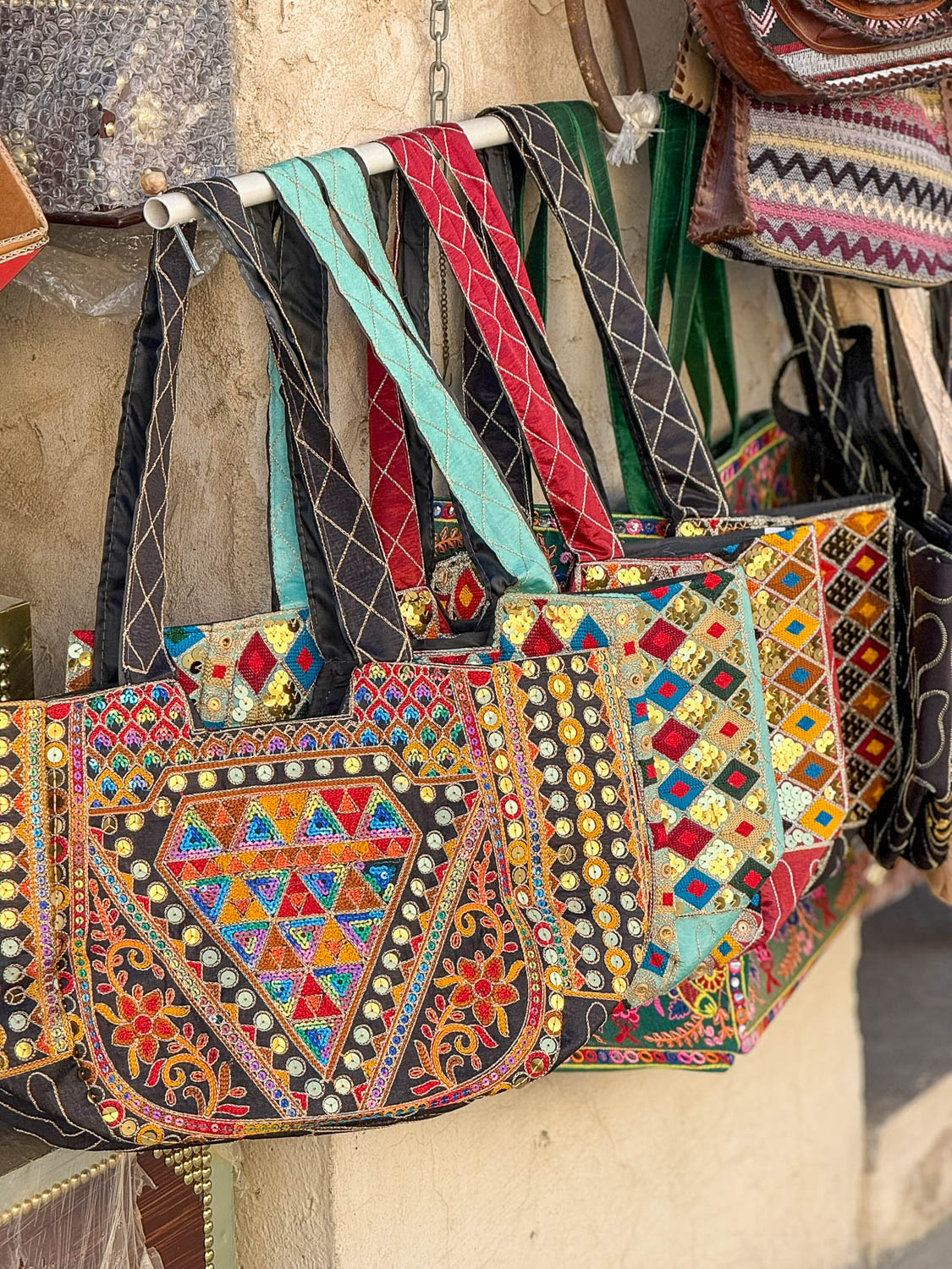 Souvenir shopping at Souq Waqif in Doha Qatar with vendors offering bags gifts and traditional items