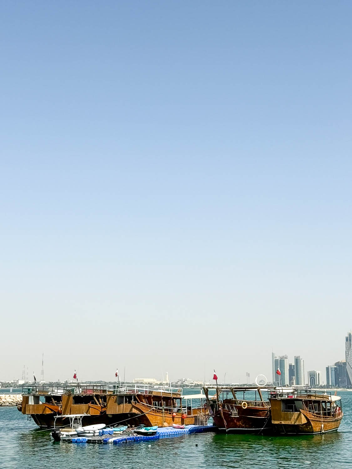 Traditional wooden dhows docked at Dhow Harbour along the Doha Corniche in Qatar