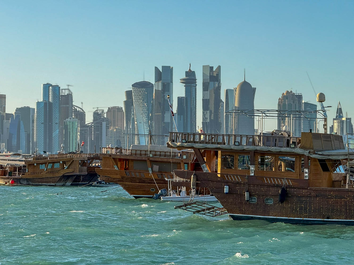 Traditional wooden dhows lined along Dhow Harbour in Doha Qatar