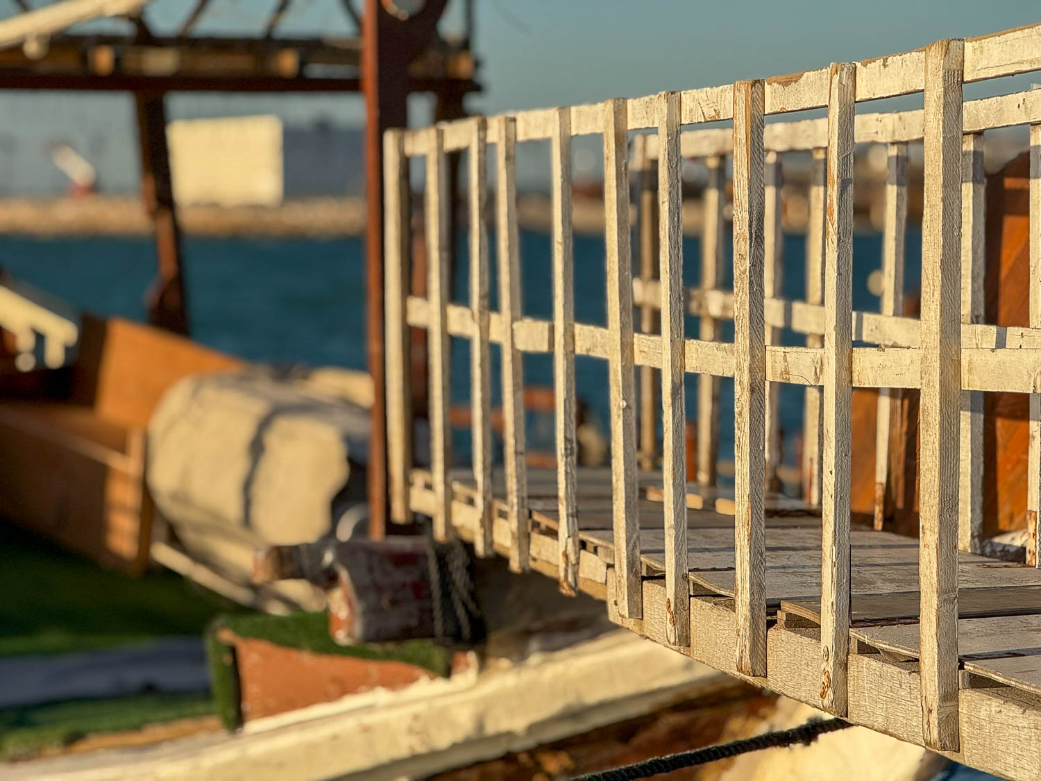 Wooden bridge leading to a traditional dhow at Dhow Harbour Doha