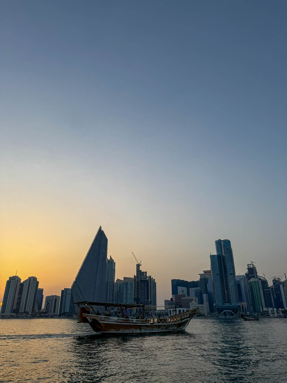 Traditional wooden dhow sailing across Doha Bay in Qatar