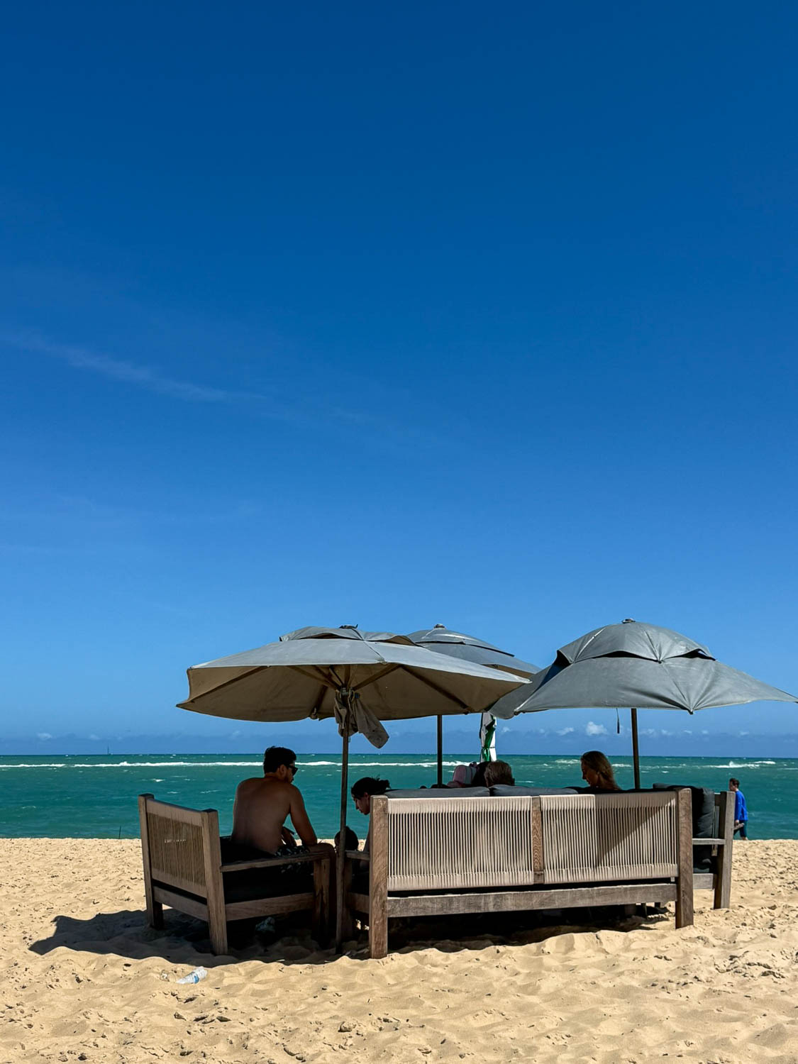 Visitor seeking shade from the strong tropical sun in Maceió Brazil during a beach day